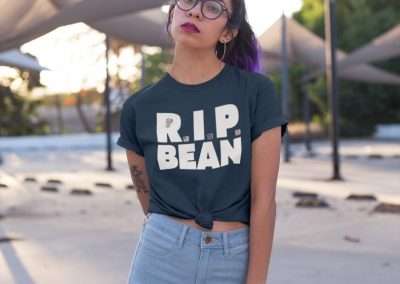woman with purple hair wearing a knotted RIP Bean tee against some tensile structure